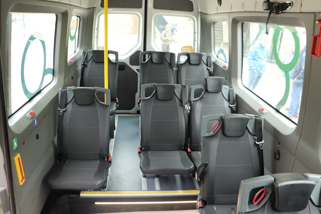 Het interieur van de nieuwe bus met zitplaatsen en ruimte bij de instap.